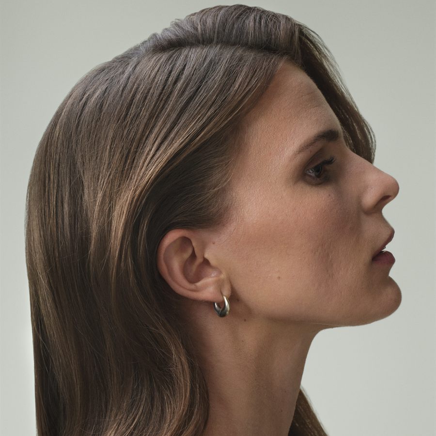 Model in profile with long bronde hair in the Bisquit Crush shade